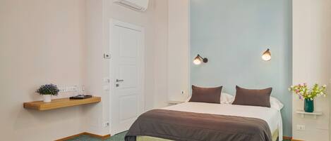 Un dormitorio con cama, mesita de noche, lámpara colgante y aire acondicionado instalado en la pared.