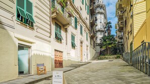 Una calle estrecha con un letrero que anuncia habitaciones disponibles, indicando un hotel o alojamiento.