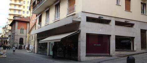 A street view with a building featuring a storefront with a sign reading "LUIGI VEZZONI".