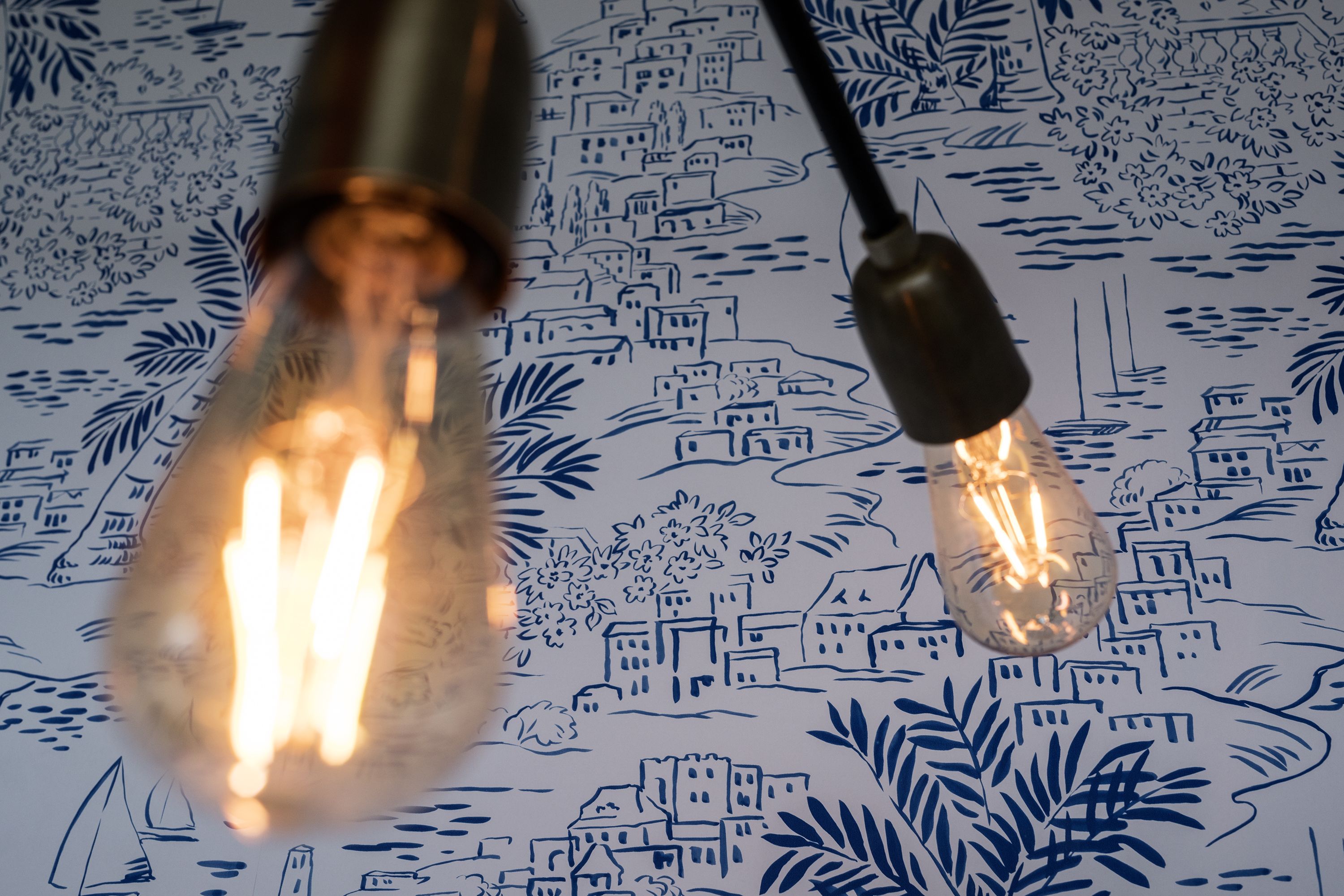 Two light bulbs with filament bulbs on a patterned surface.