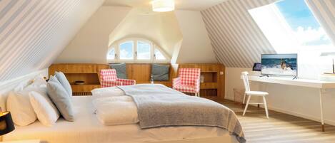A bedroom with a bed, a desk, a chair, and a window.