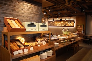 A breakfast buffet with various pastries and bread, a coffee station, and a seating area with tables and chairs. - Hotel Global View Hakodate (Hakodate)