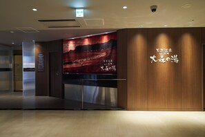 A modern hotel lobby with a large wall mural, a reception desk, and wooden paneling. - Hotel Global View Hakodate (Hakodate)