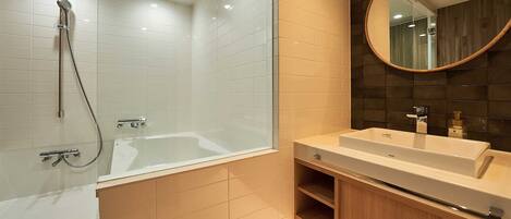 A modern bathroom with a glass-enclosed shower, a white bathtub, and a vanity with a mirror.