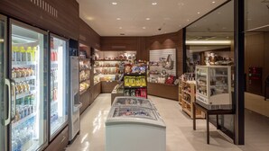 Un supermercado bien iluminado con secciones refrigeradas a la izquierda, un área de exhibición central y una panadería a la derecha.