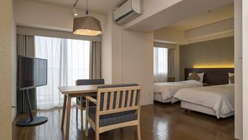 A hotel room with a TV, a dining table, two beds, and a large window with curtains.