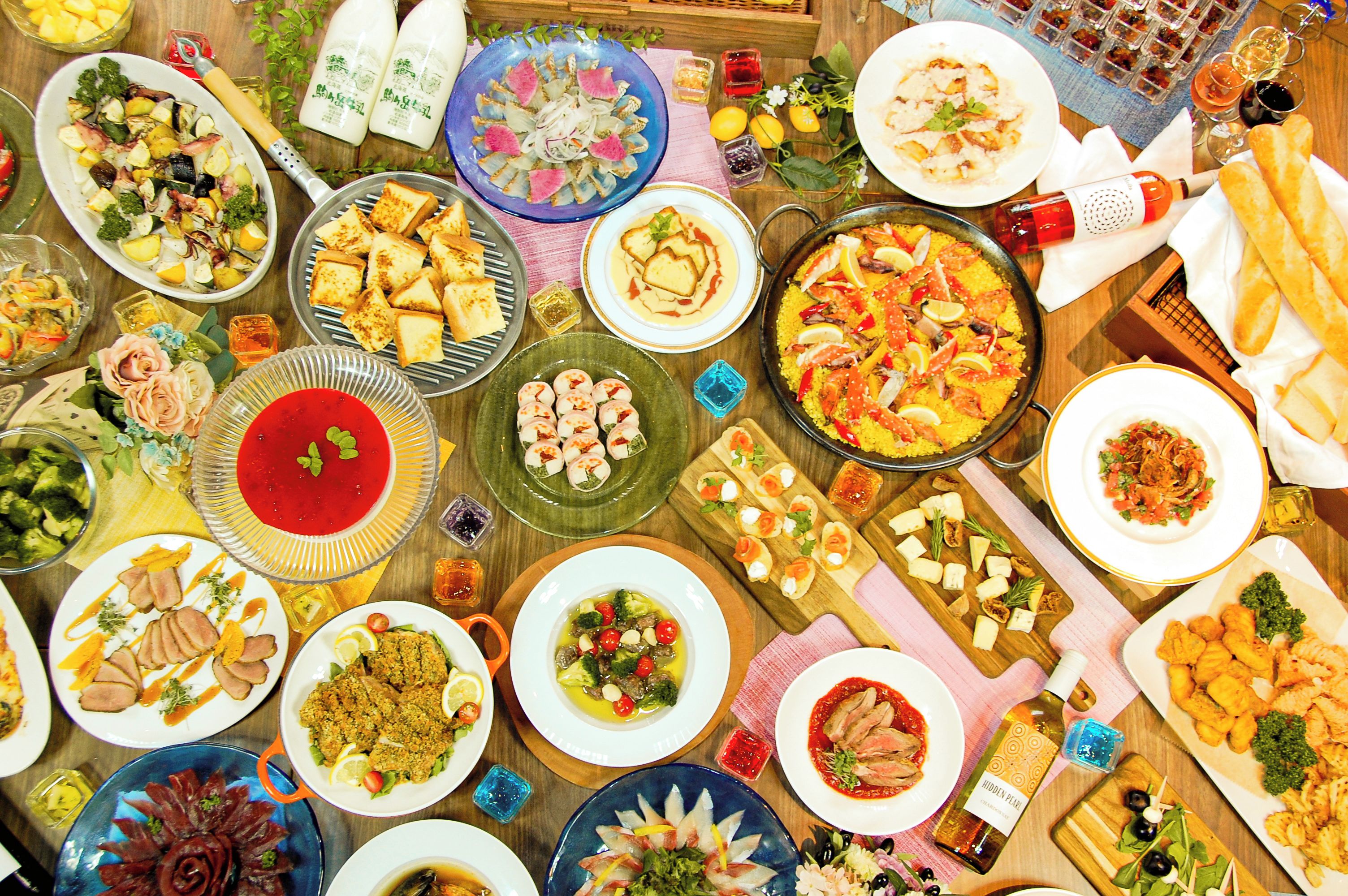 A variety of dishes and food items arranged on a table, suggesting a buffet or communal dining setting.