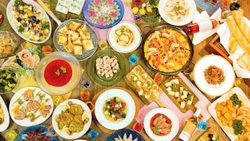 A variety of dishes and food items arranged on a table, suggesting a buffet or communal dining setting.
