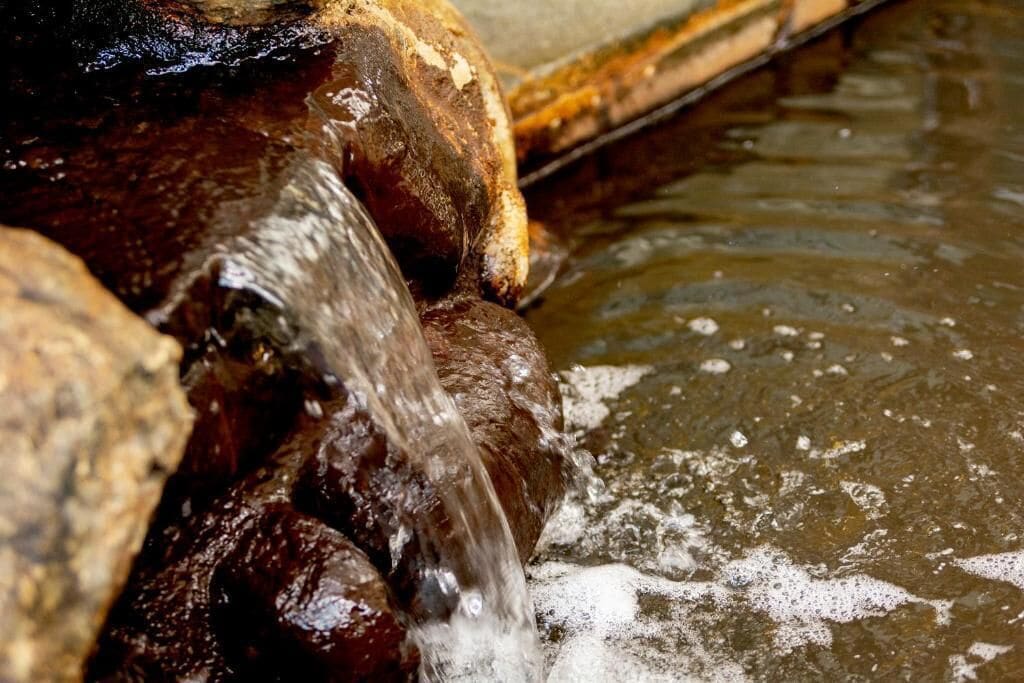 A close-up of a water feature with flowing water over rocks.