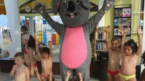 A mascot with raised arms surrounded by children in swimwear. - Hotel Nova Dhely (Rimini)