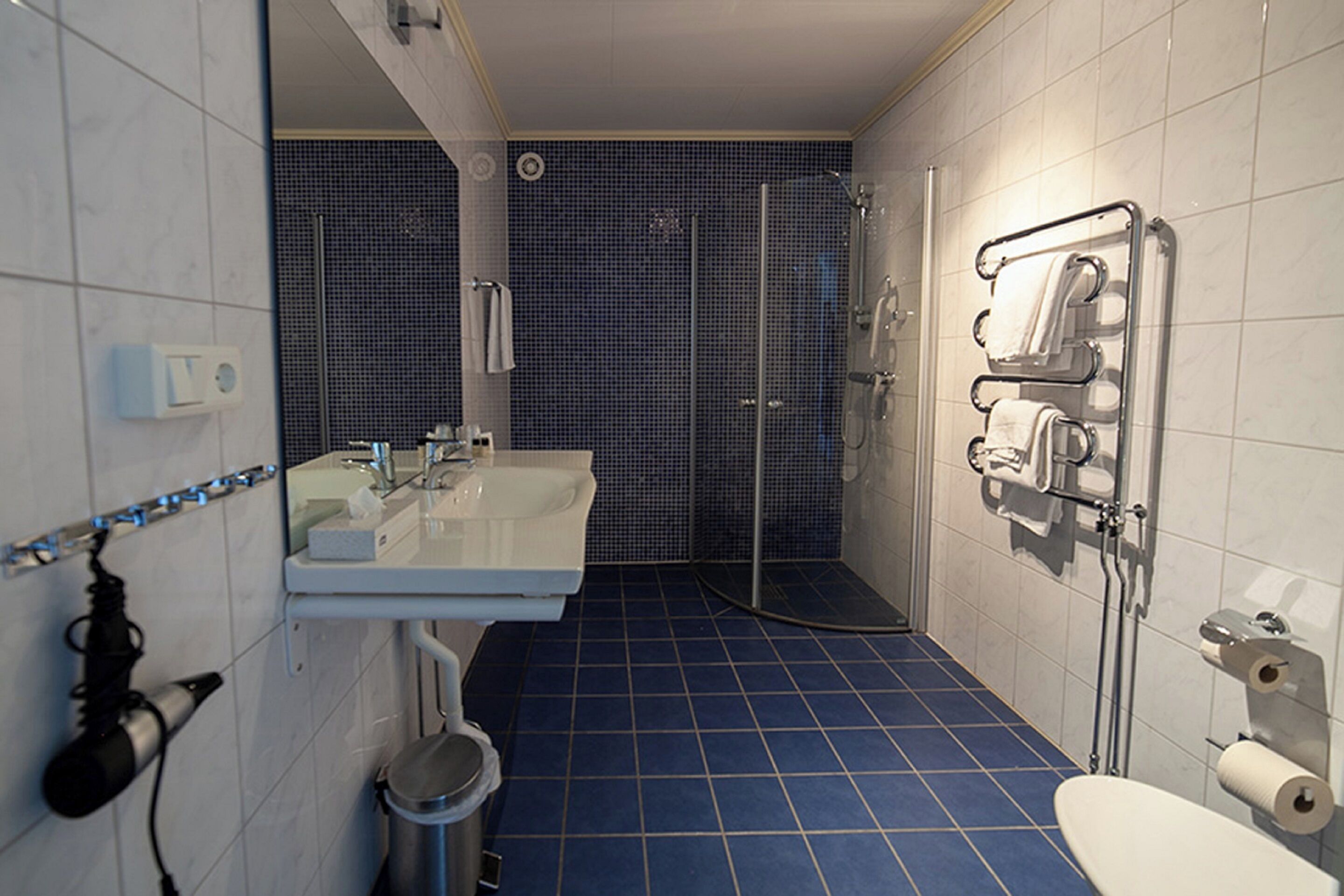 Un bagno con lavandino, specchio e zona doccia.