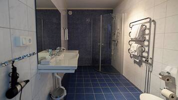 Un bagno con lavandino, specchio e zona doccia.