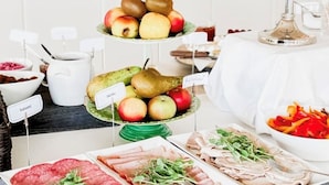 A buffet table with various food items including fruits, vegetables, and meats. - Hotell Ronja (Vimmerby)