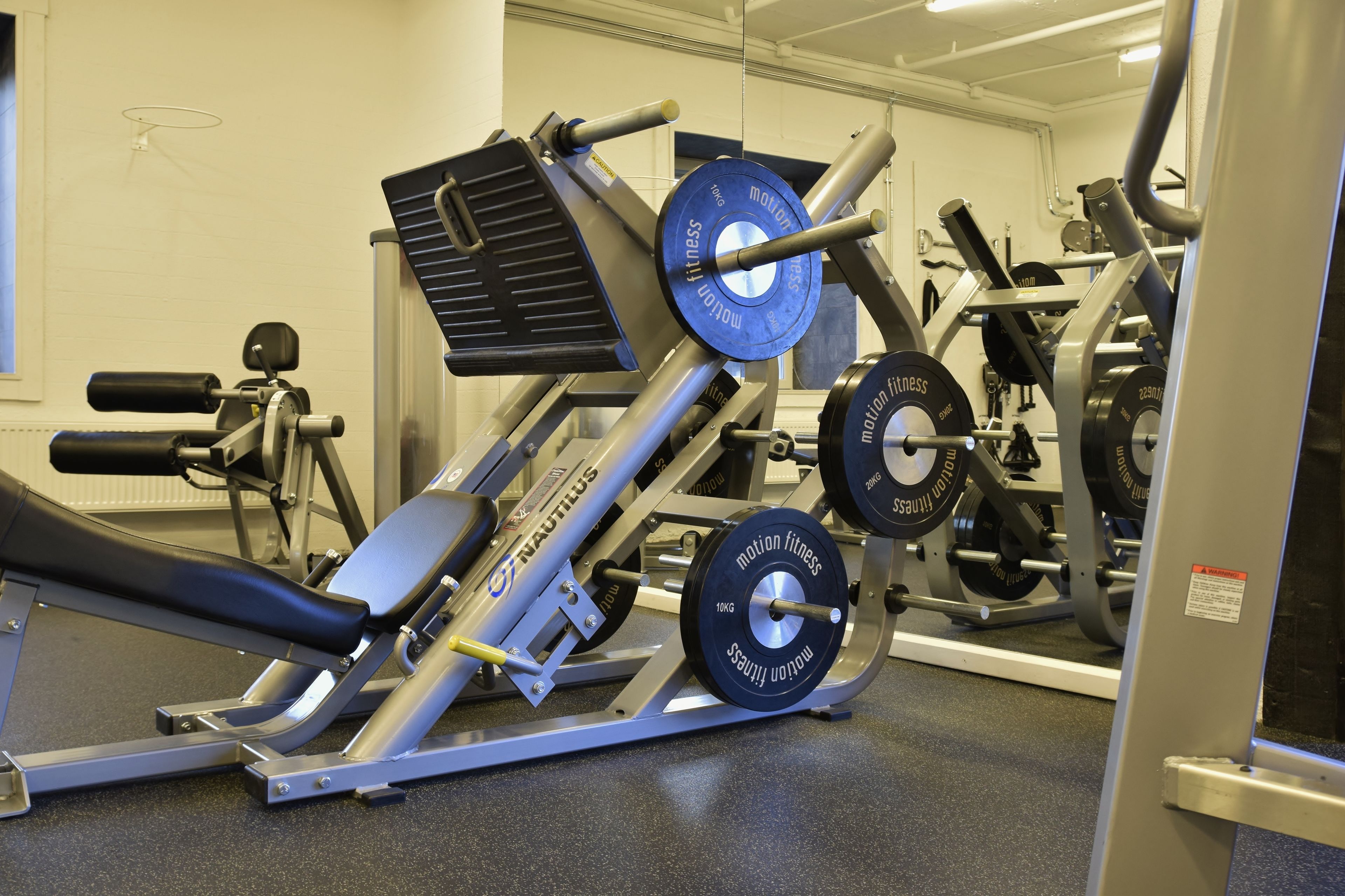 A gym with Nautilus equipment, including a leg press and a chest press machine.