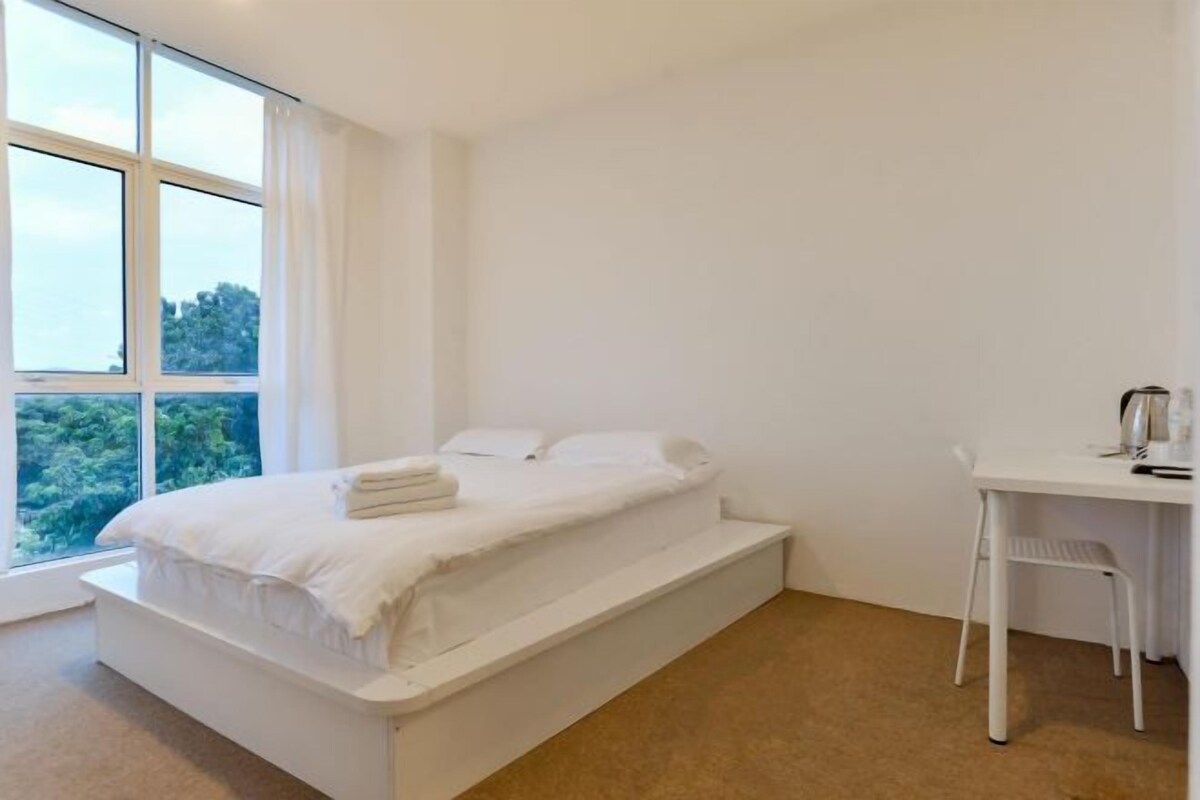 Une chambre à coucher avec un lit, un bureau et une fenêtre.