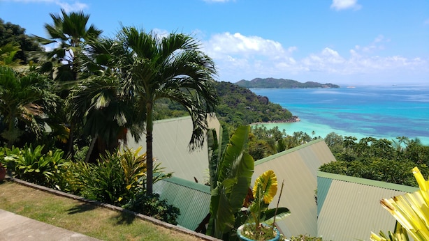 Un resort tropical con vista al océano y un paisaje montañoso.