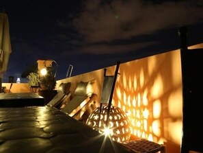 A rooftop terrace with a table, chairs, and a decorative lantern. - Dar Andamaure (Marrakech)