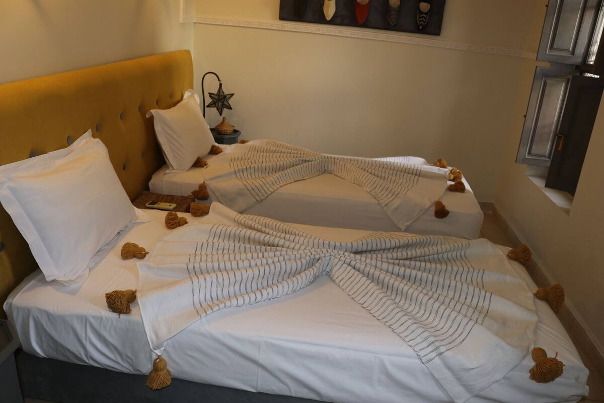 A hotel room with two beds, white bedding, and a star-shaped nightstand lamp.