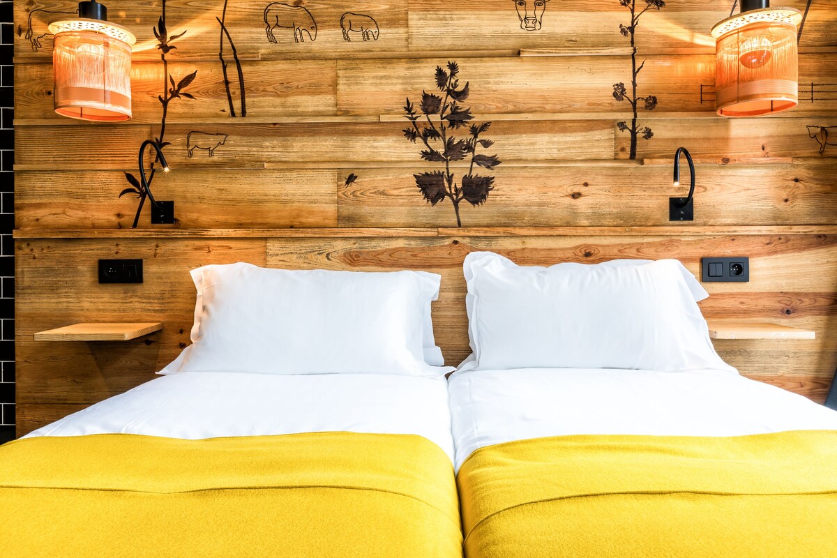 Eine Holzwand mit einem Bett, zwei Nachttischen und zwei Wandleuchten.
