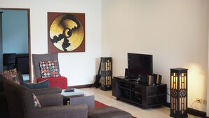 A living room with a sofa, a coffee table, a TV, and decorative items.