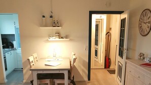 A modern apartment with a dining area, kitchen, and living room. - Haus Stedum - App. Lenz (Sylt)