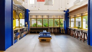 Een moderne hotellobby met een centraal zitgedeelte, barstoelen en verschillende lockers.
