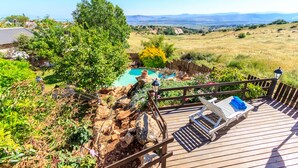 A wooden deck with a pool, surrounded by greenery and a view of distant mountains. - Betzel Haella (Mevoot HaHermon)