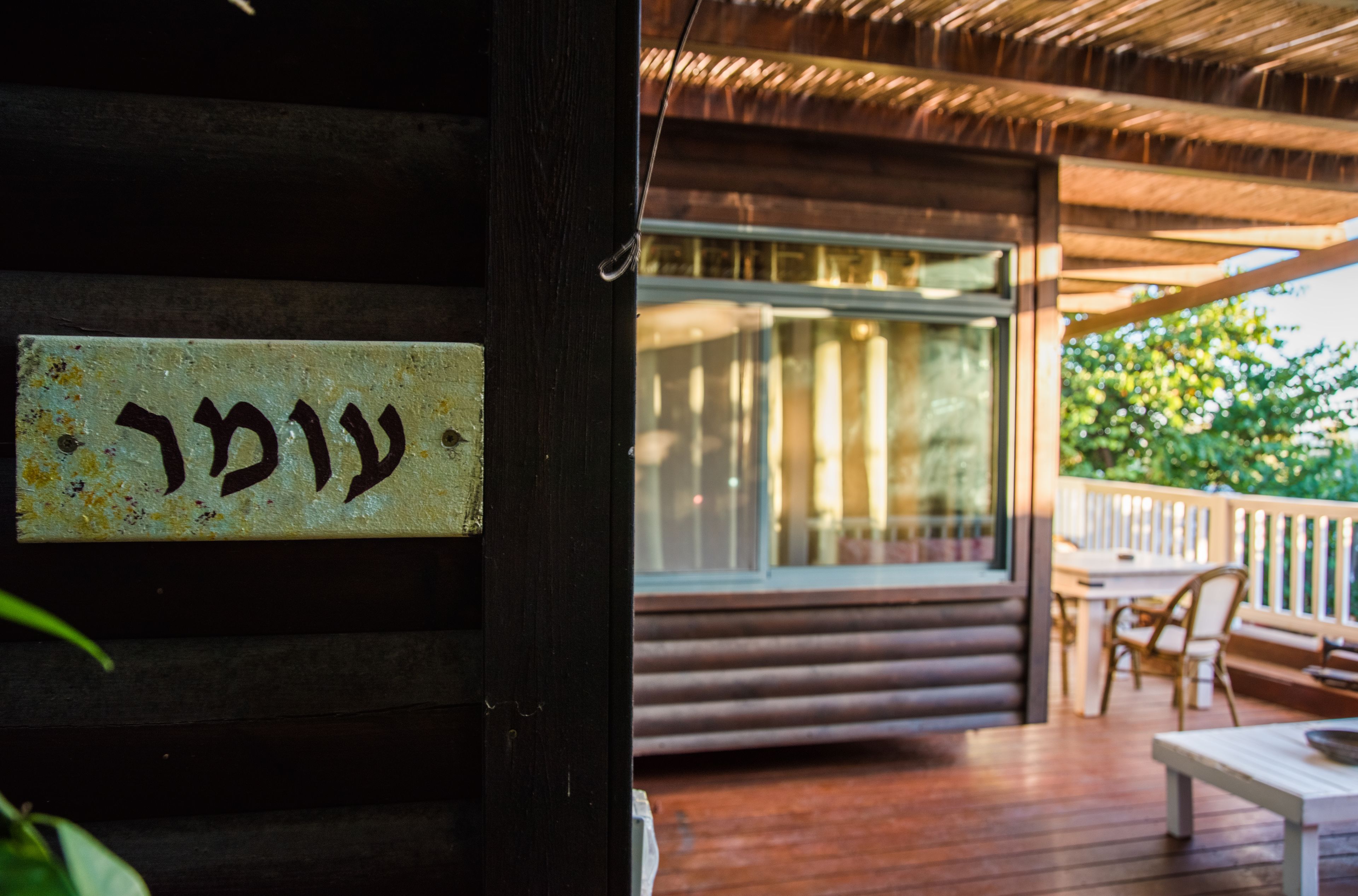 Una cabaña de madera con un ventanal grande y una terraza.