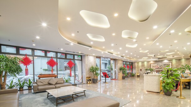 A modern hotel lobby with a reception desk, seating area, and large windows. - Seaman Hotel Guangzhou (Guangzhou)
