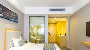 A hotel room with a large bed, a bathroom with a glass partition, and a small kitchenette. - Seaman Hotel Guangzhou (Guangzhou)