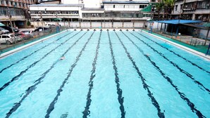 A large indoor swimming pool with multiple lanes, surrounded by buildings. - Seaman Hotel Guangzhou (Guangzhou)