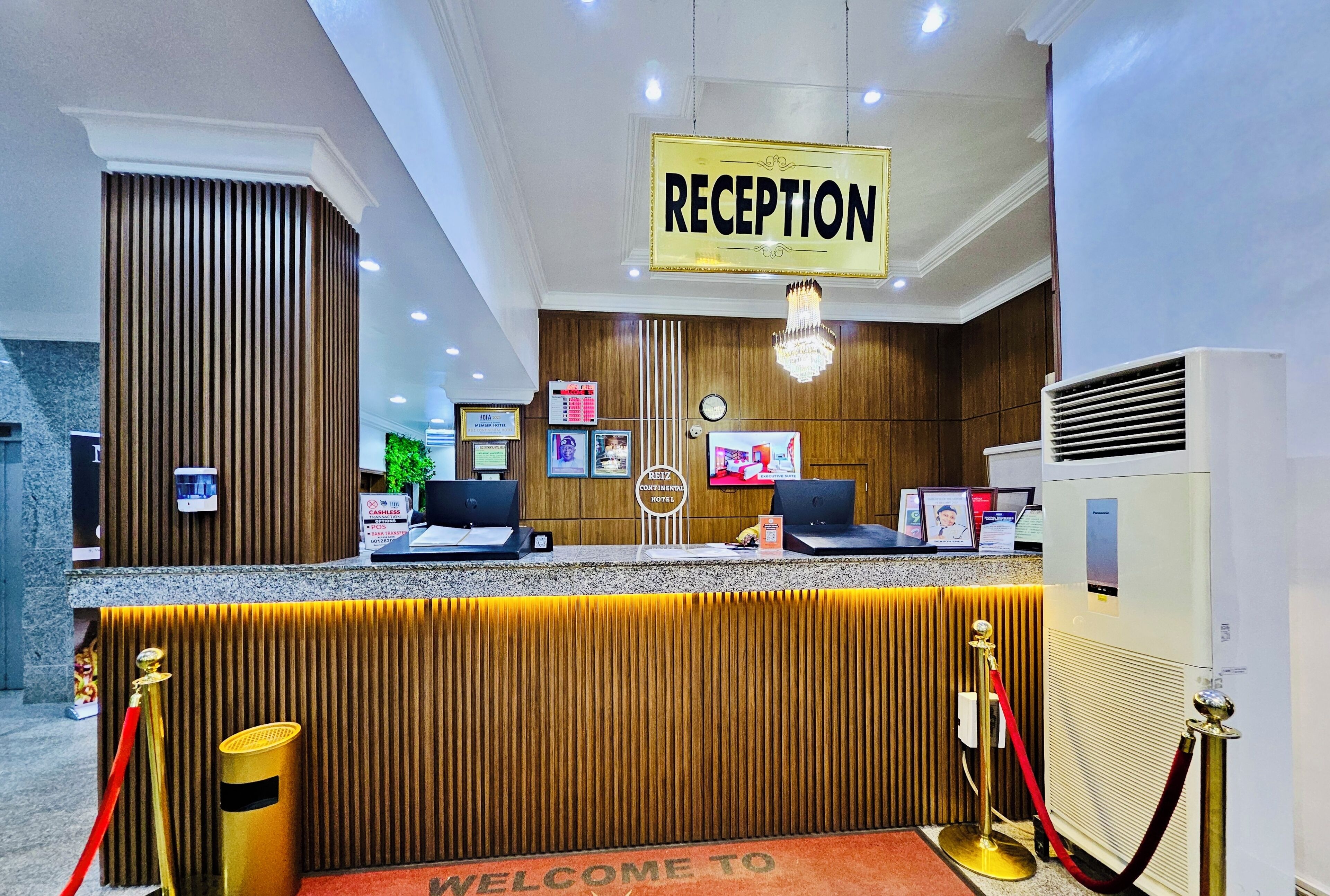 A hotel reception area with a reception desk, a clock, and a sign indicating the reception.