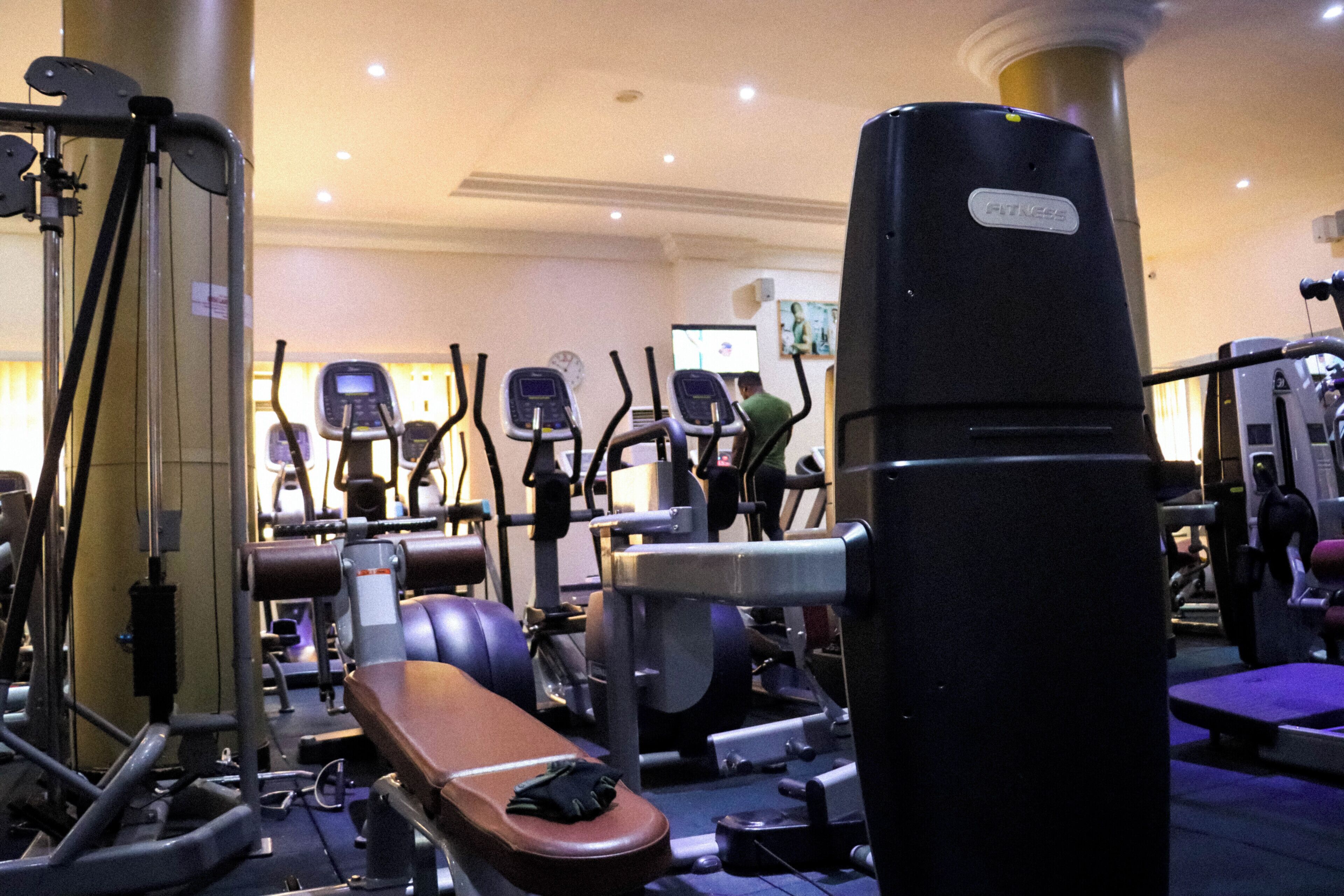 A gym with various exercise machines, including treadmills and weight machines.
