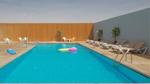A swimming pool with lounge chairs and a wooden deck. - Soho Eilat (Eilat)