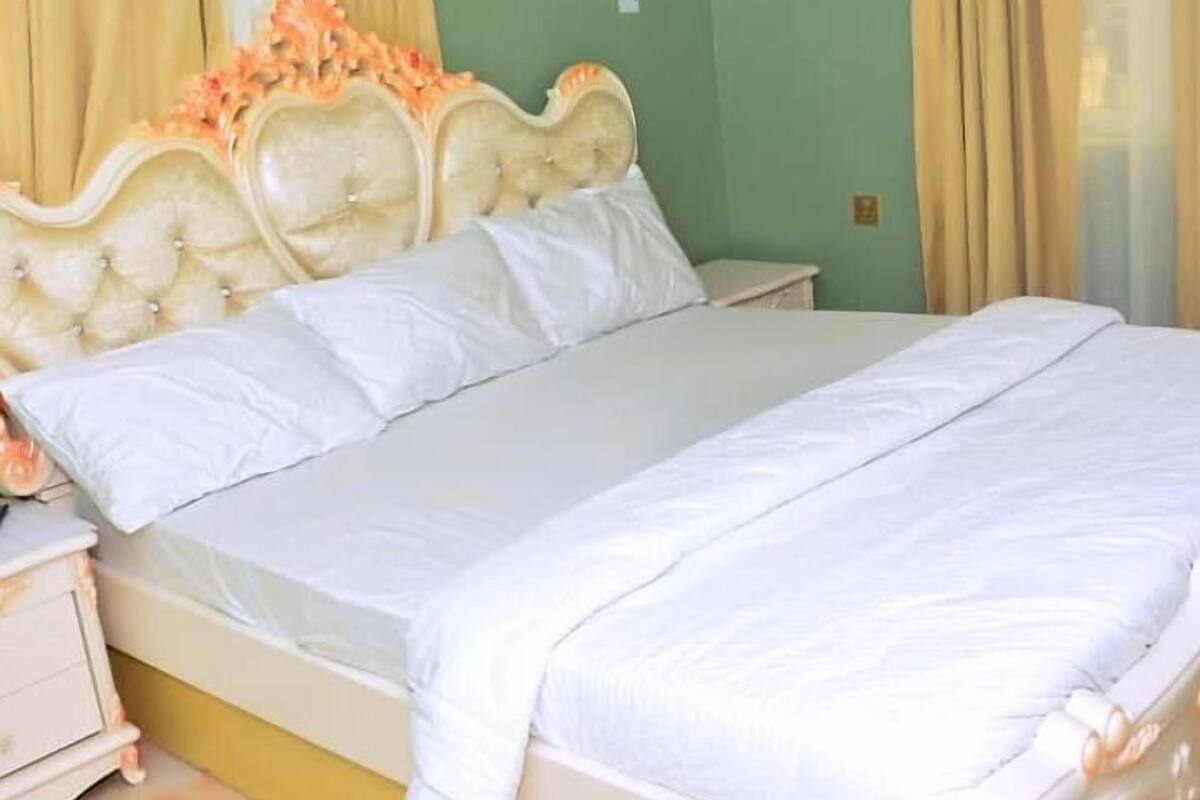 A bed with a headboard, a bedside table, and curtains.
