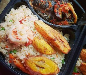A meal with rice, shrimp, fried plantains, and a fish dish. - Afri Hotel (Abuja)
