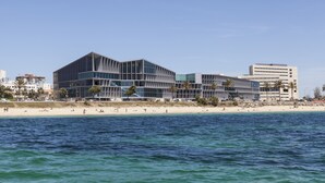 Ett modernt hotell med en unik arkitektonisk design, beläget nära en strand med utsikt över havet.