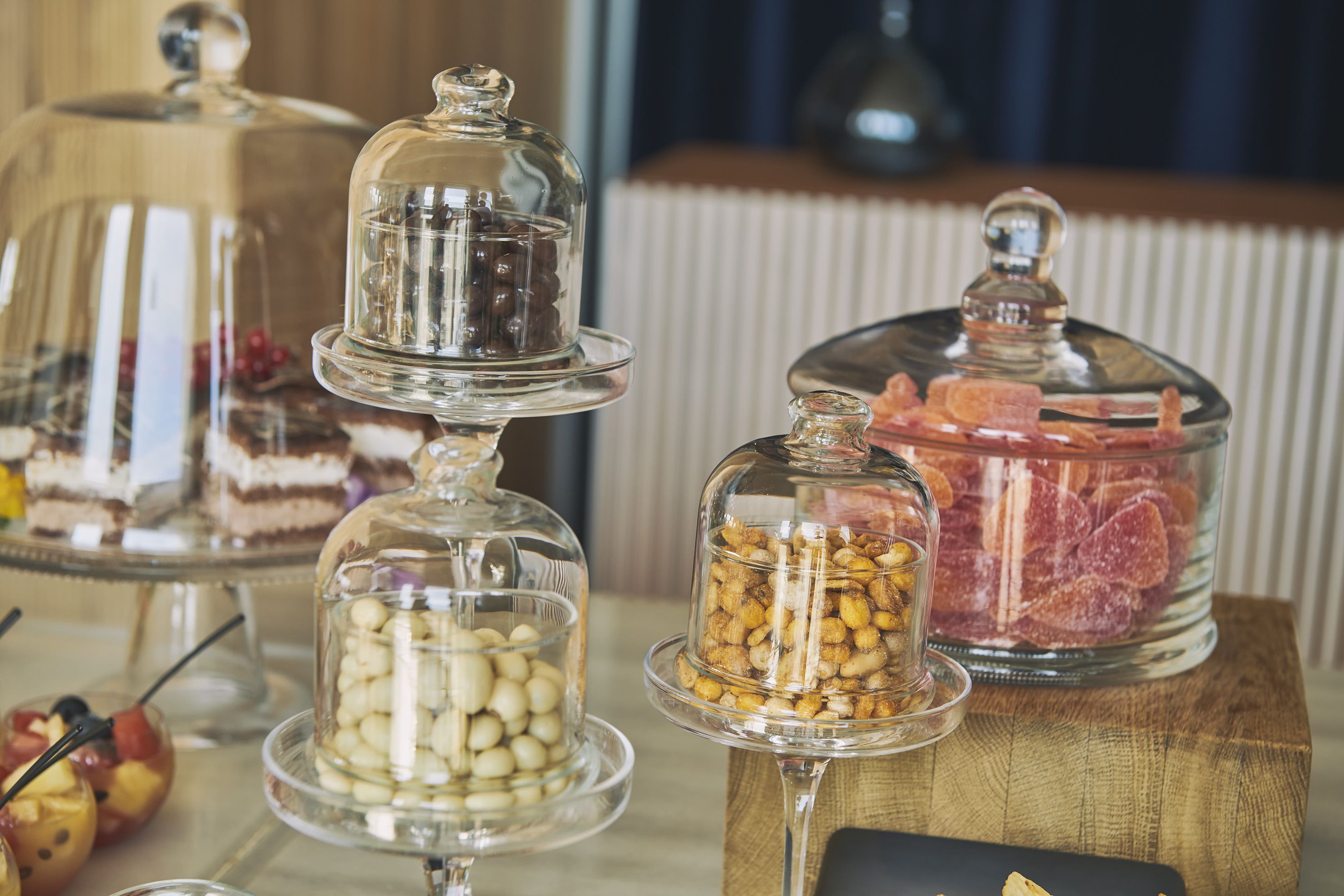 A buffet table with various food items covered in glass domes.