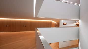 Un interior moderno con suelo de madera, paredes blancas e iluminación empotrada.