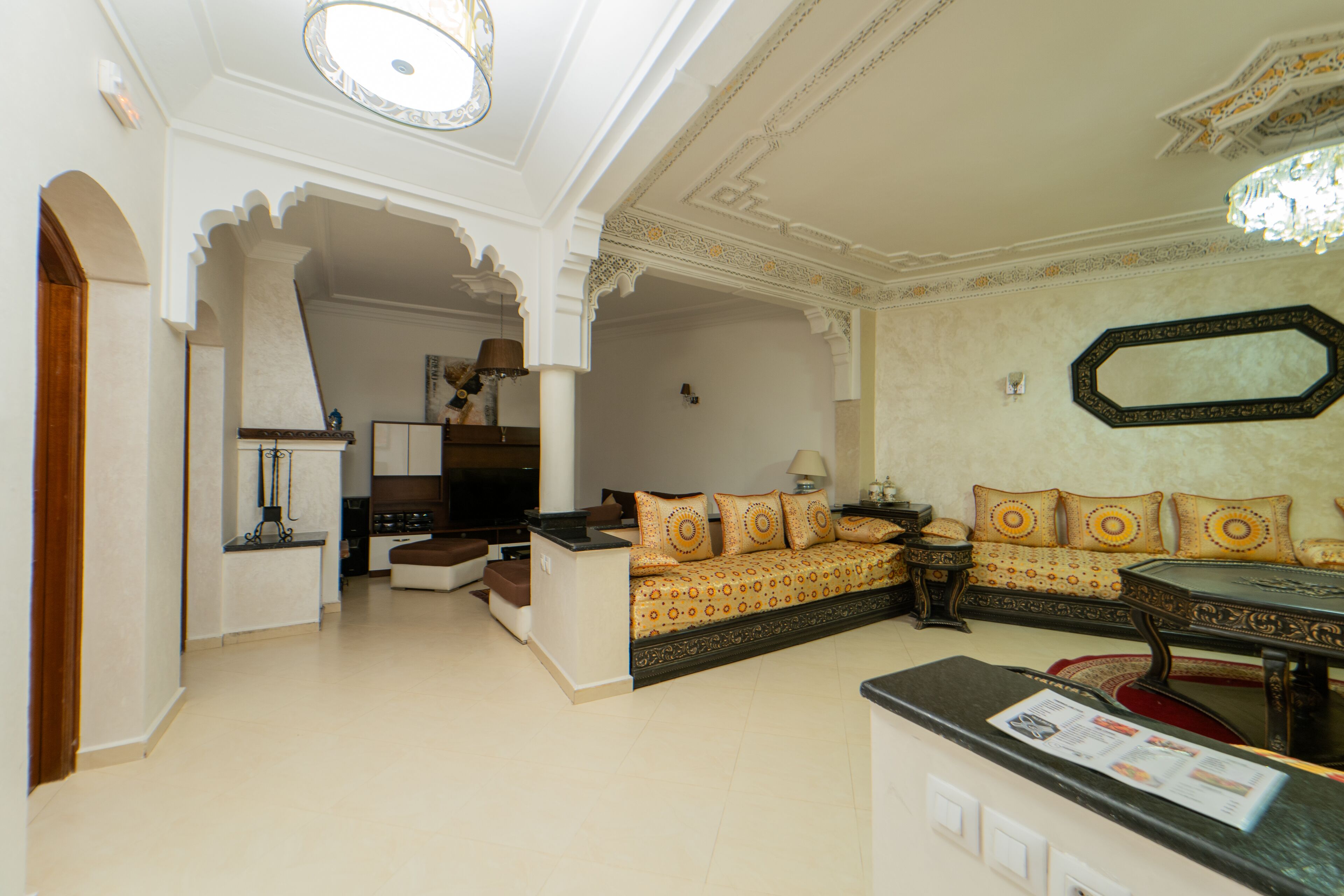 A living room with a sofa, a coffee table, and a TV. There is a door leading to another room.
