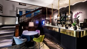A bar area with a wooden staircase, a round table, and two chairs. - Hotel The Haven Roma (Rome)