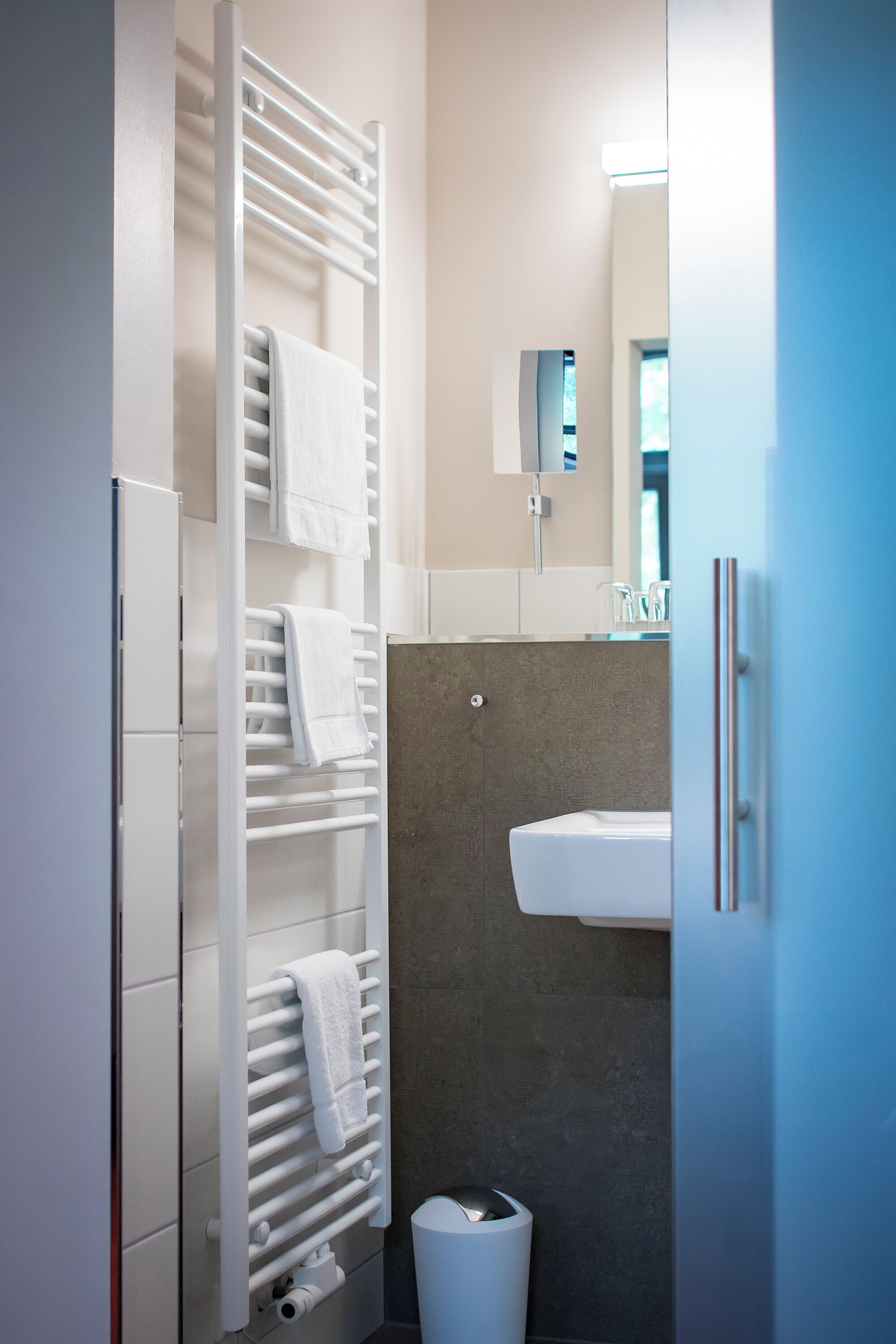 Une salle de bain moderne équipée d’un porte-serviettes intégré, de toilettes et d’un lavabo.