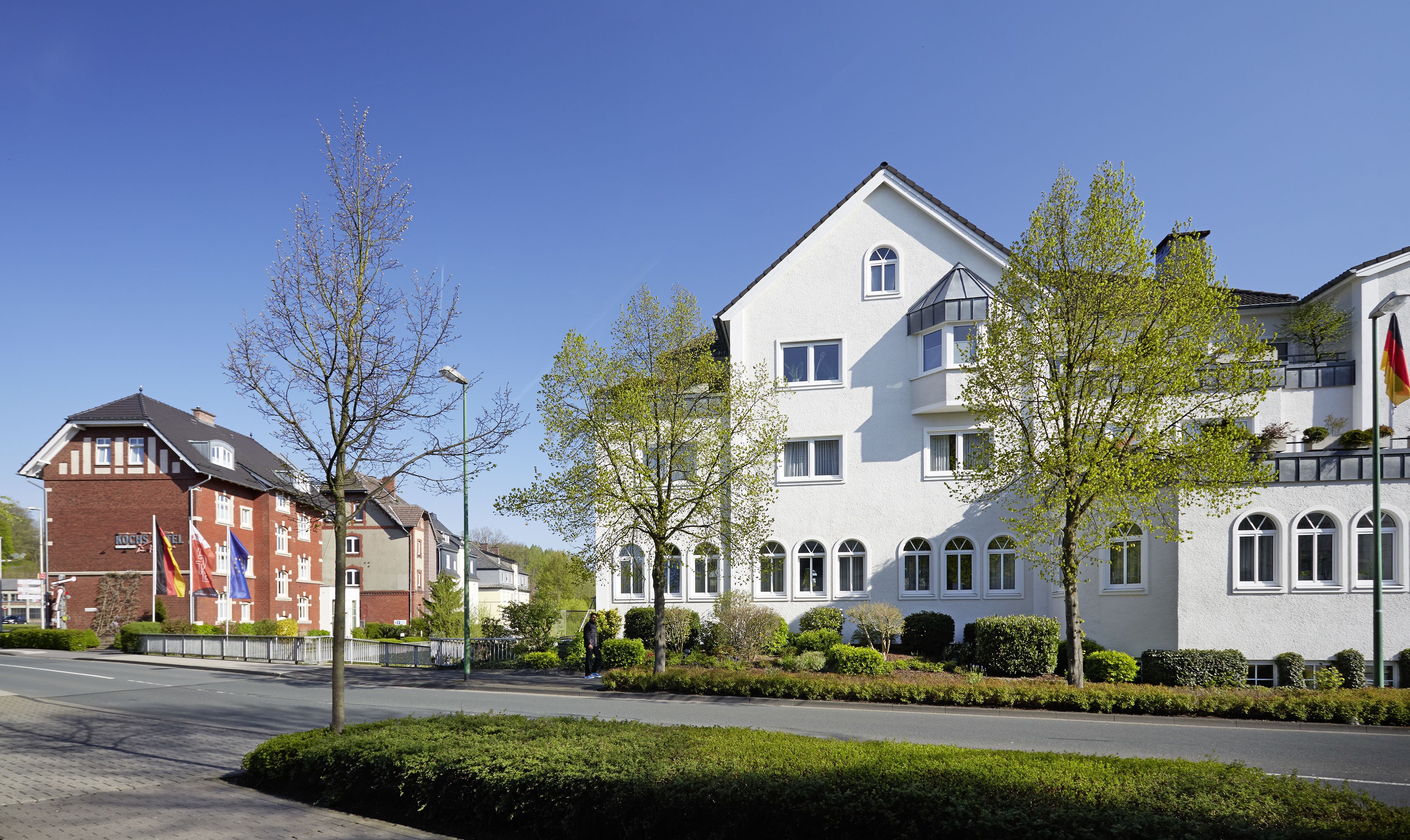 A row of modern two-story buildings with large windows and a well-maintained lawn.