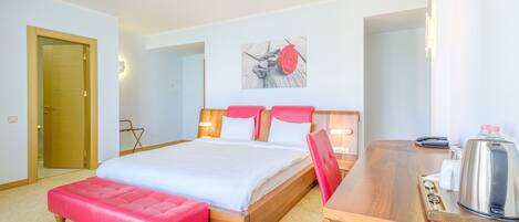 Una habitación de hotel con una cama, un escritorio, una silla y una cafetera.