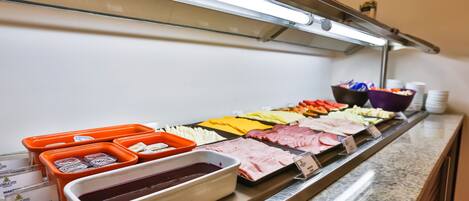 Un bufé con diversas opciones de comida y salsas.
