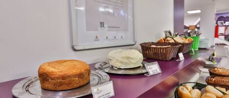 A bakery display with a loaf of bread and a cake on a purple counter.