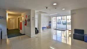 A clean, modern lobby with a reception desk, seating area, and a large glass door leading outside. - Nobile Inn Pampulha (Belo Horizonte)