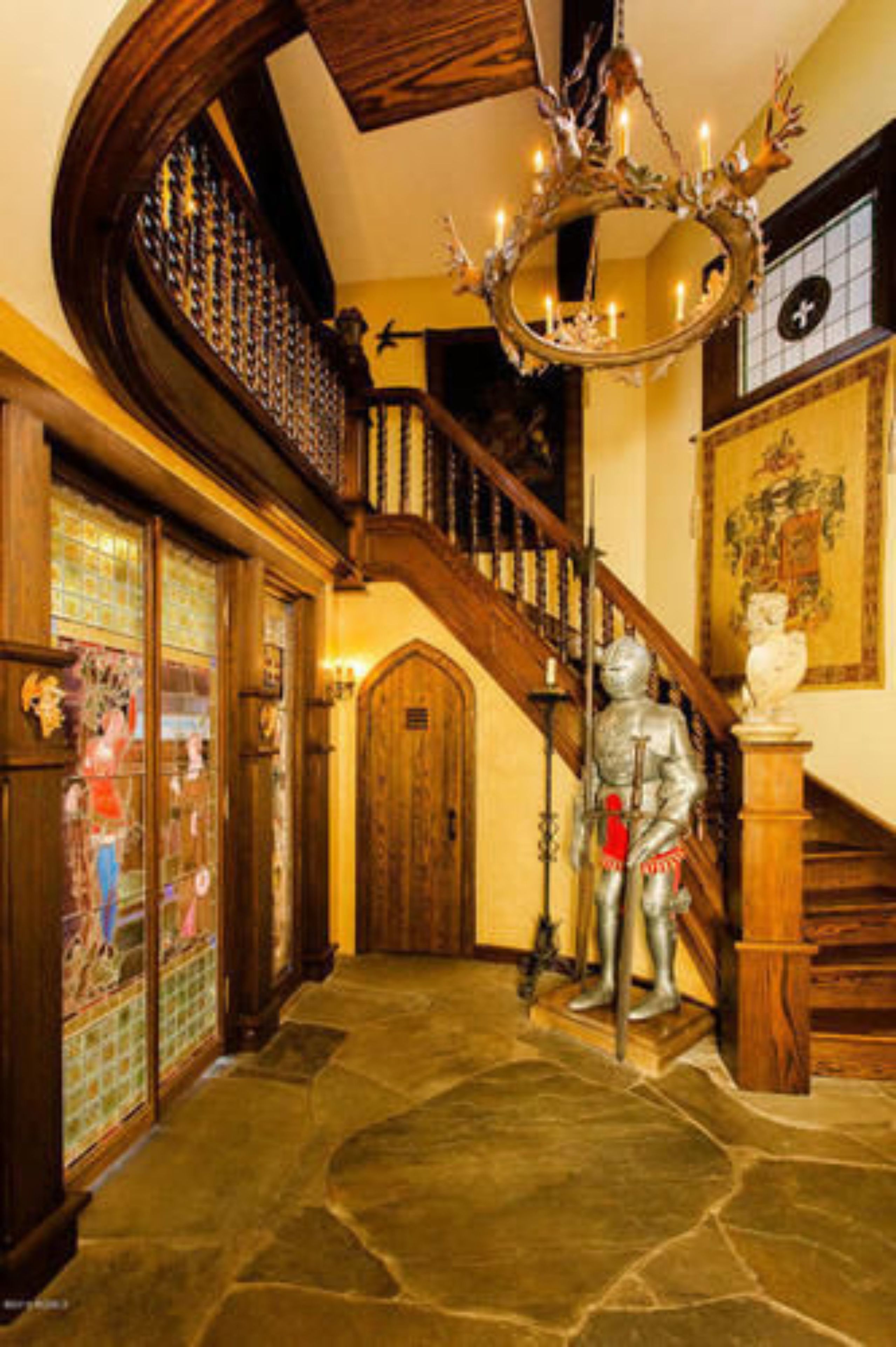 A grand staircase with a wooden handrail and a chandelier.