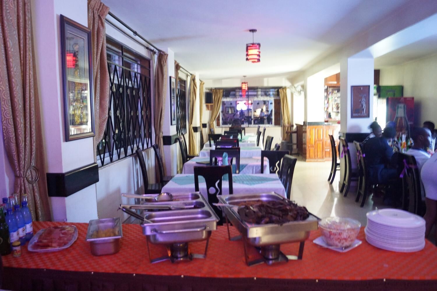 Ein Buffet mit mehreren Servierstationen, einer Bar und einem Sitzbereich mit Tischen und Stühlen.
