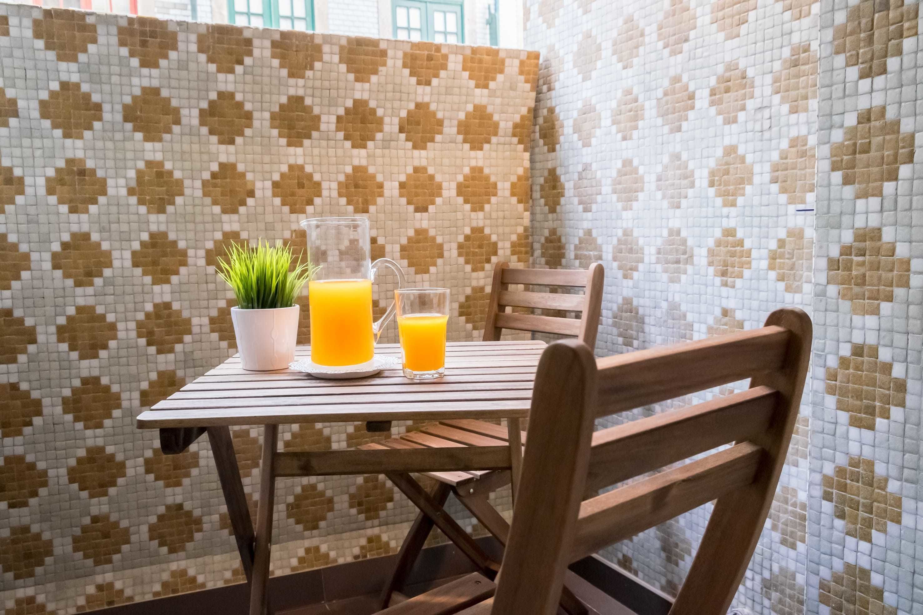 Ein Tisch mit einer Topfpflanze und zwei Gläsern Orangensaft.